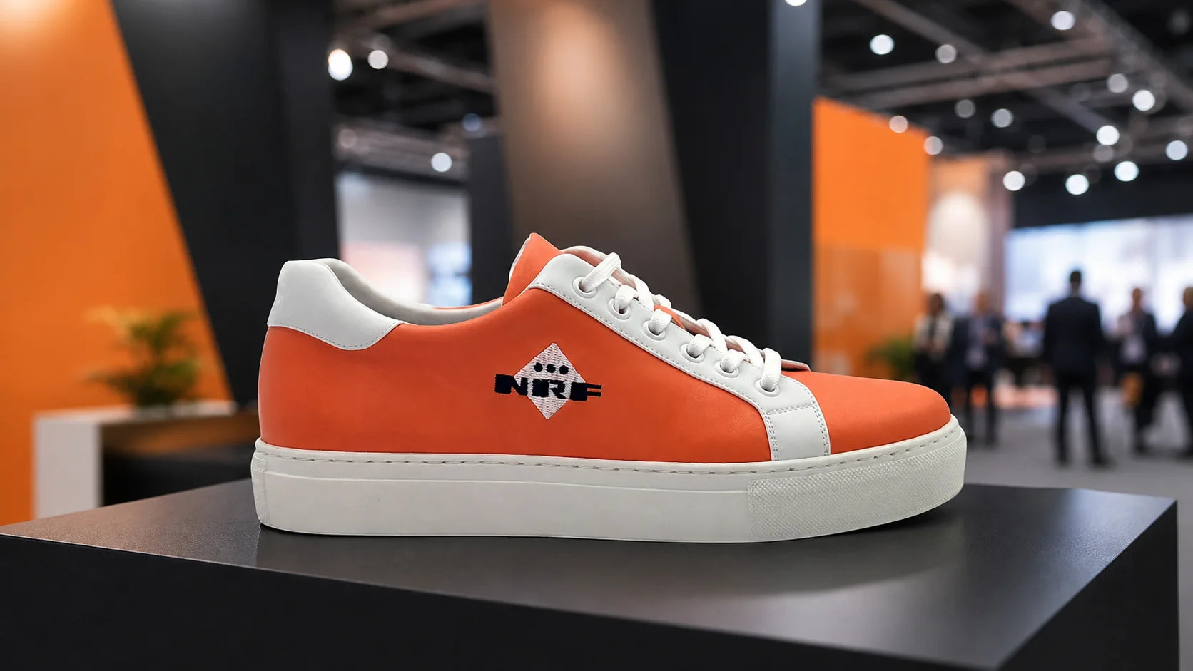 Custom branded orange sneaker displayed at a professional trade fair